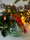 Close-up view of Green Christmas ornament with white tree design