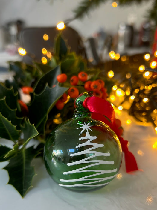 Close-up view of Green Christmas ornament with white tree design